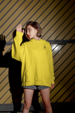 girl wearing super driven  bee focused sun yellow hoodie posing in a serious way with her hand up 