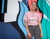 pretty girl smiling in front of a colorful illustration wearing pink super driven unique motivational t-shirt a great present for entrepreneurs